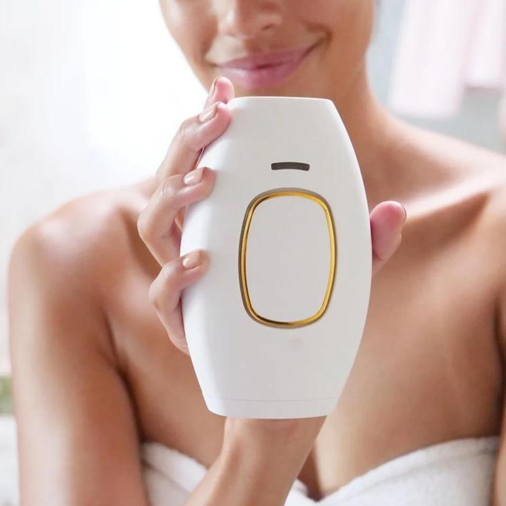 Person holding a white electronic device with a gold accent